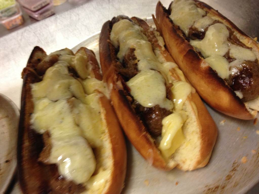 Bishop Sessa skinless wagyu sausage hot dogs with pickled onions, mustard and melted cheddar